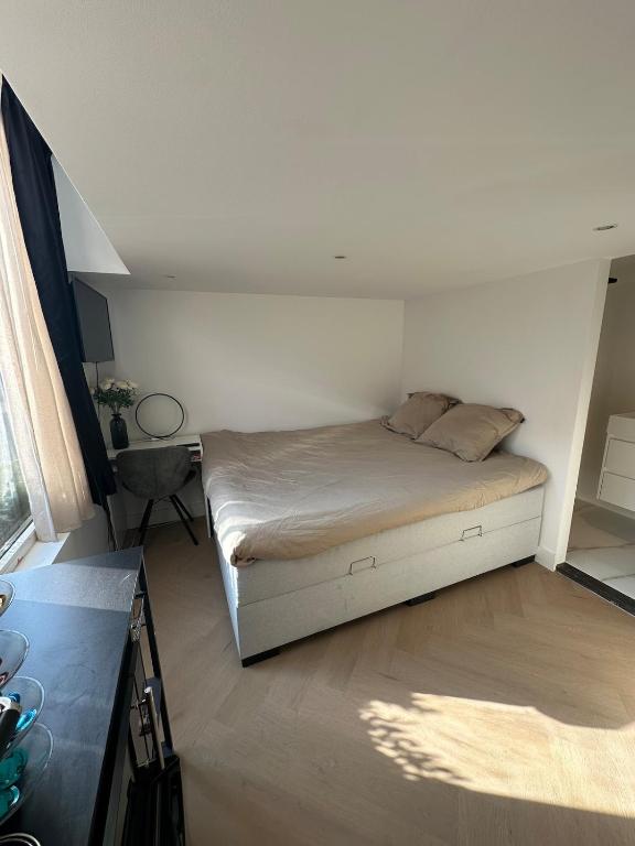 a small bedroom with a bed and a desk at WaalPlaat's B&B in Amsterdam