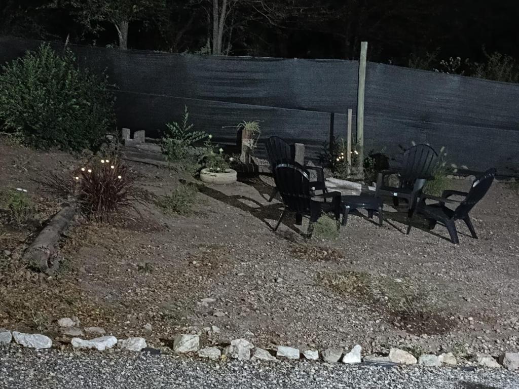 a group of benches sitting in a yard at night at cabañas Saona in Molinari