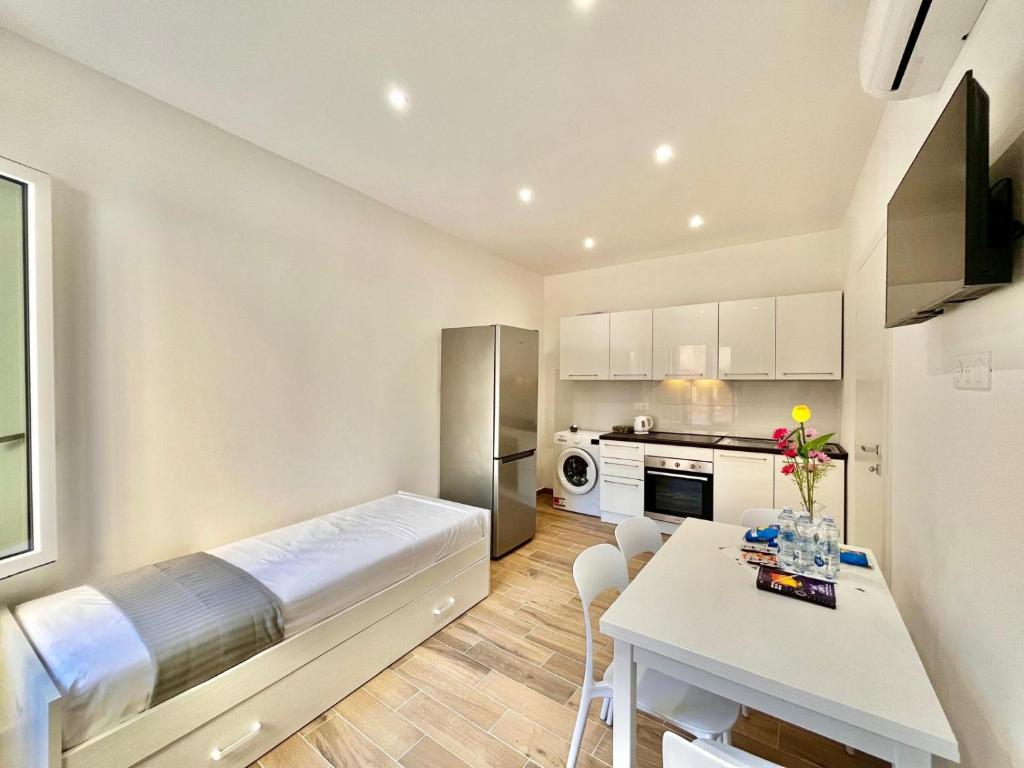 Cette petite chambre comprend un lit et une table. dans l'établissement Bilocale Azur- Menton centro, à Menton