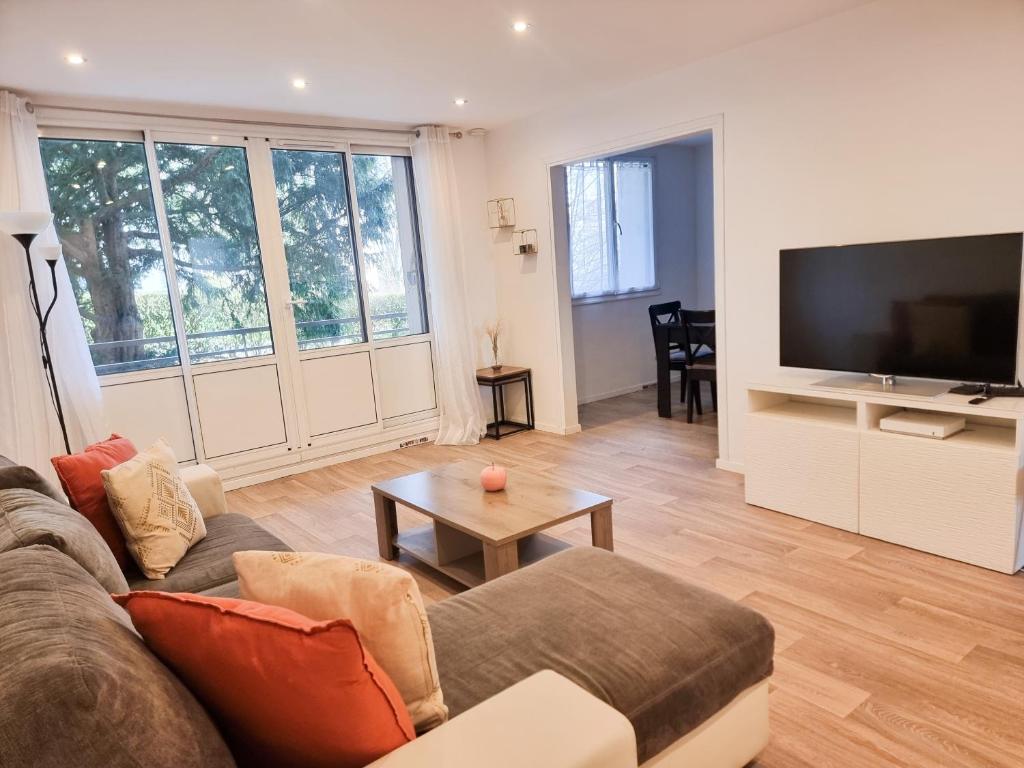 un salon avec un canapé et une télévision à écran plat dans l'établissement 3-4 pièces (65 m2) à Bois d’Arcy, à Bois-dʼArcy