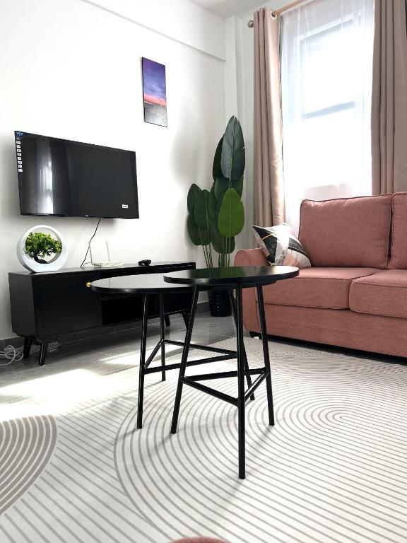 a living room with a table and a couch at Zen Studio for your Rest and Unwind in Nairobi