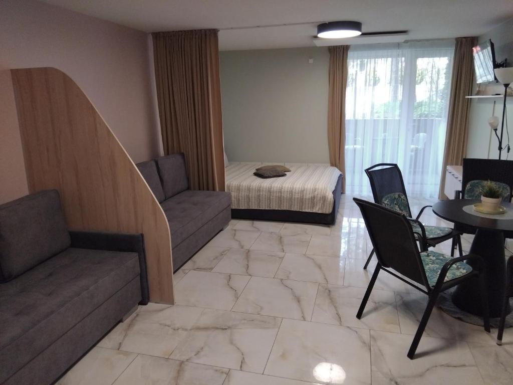 een woonkamer met een bank, een bed en een tafel bij Apartamentai Gintaras in Palanga