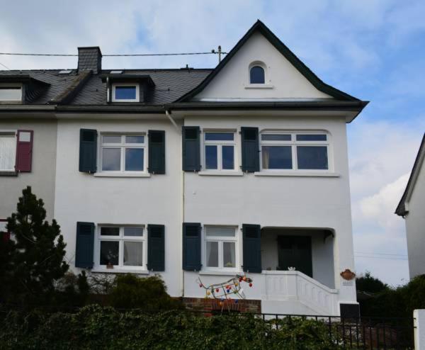 uma casa branca com janelas azuis e uma cerca em Haus zum Rhein em Lahnstein