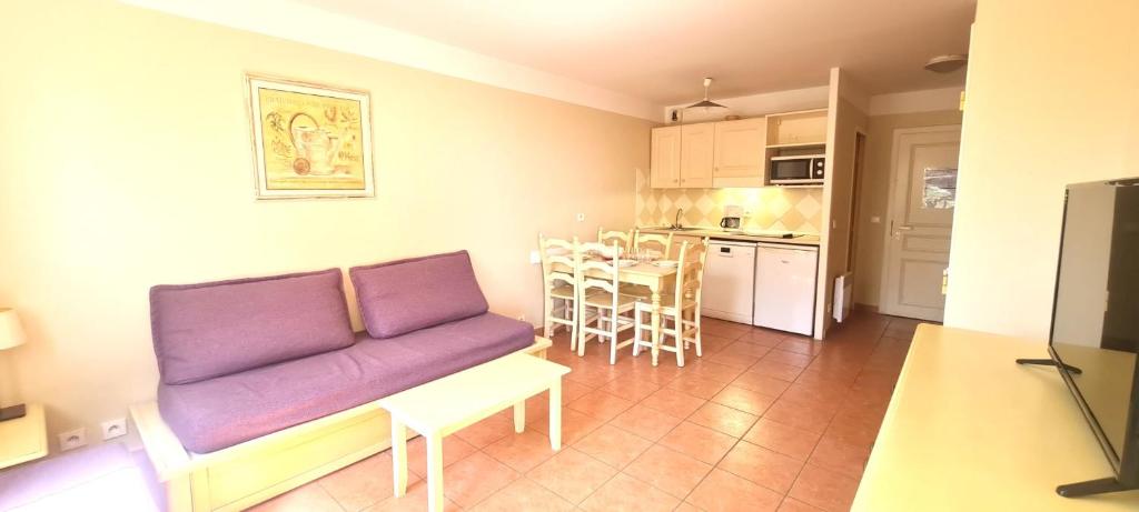 Il comprend un salon avec un canapé violet et une cuisine. dans l'établissement Apartment with sea view in Roquebrune-sur-Argens, à Roquebrune-sur Argens