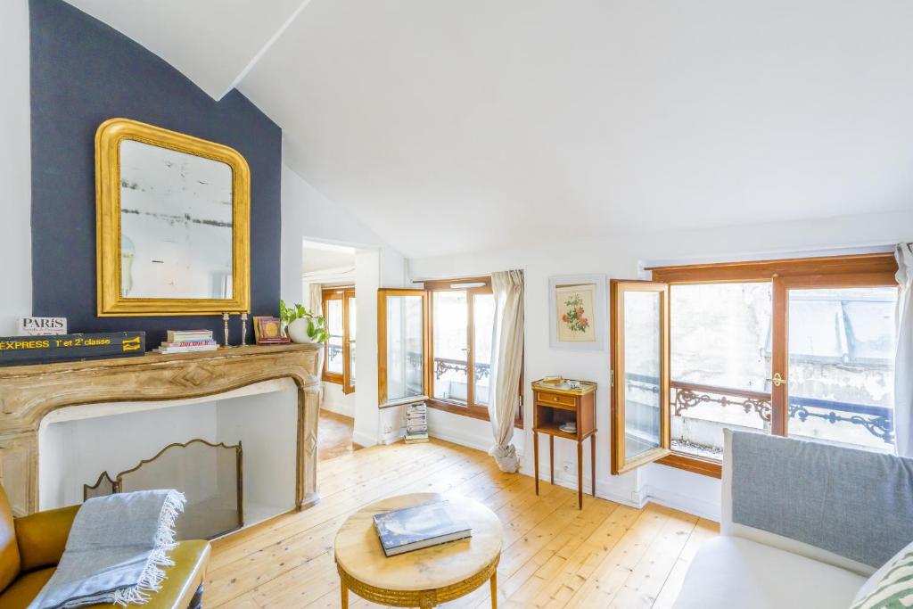 ein Wohnzimmer mit Kamin und Couch in der Unterkunft Proche Château Appartement Calme & Familiale in Versailles