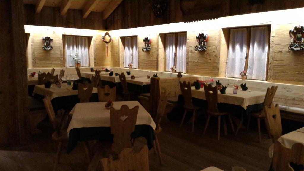 a dining room with tables and chairs in a room at Jägerhaus Agriturismo in Cortina dʼAmpezzo