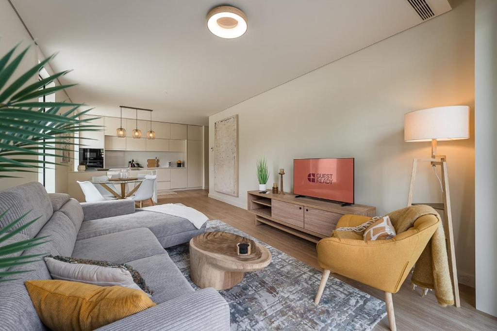 a living room with a couch and a tv at GuestReady - Bright & Inviting Stay in Vila Nova de Gaia