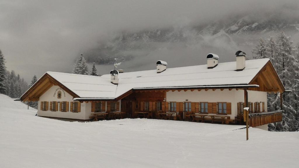 a house with snow on the roof in the snow at Jägerhaus Agriturismo in Cortina dʼAmpezzo