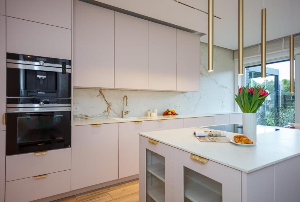 a kitchen with white cabinets and a counter with flowers at Unique House for Football Fans-Wroclaw Final- near Stadium in Wrocław