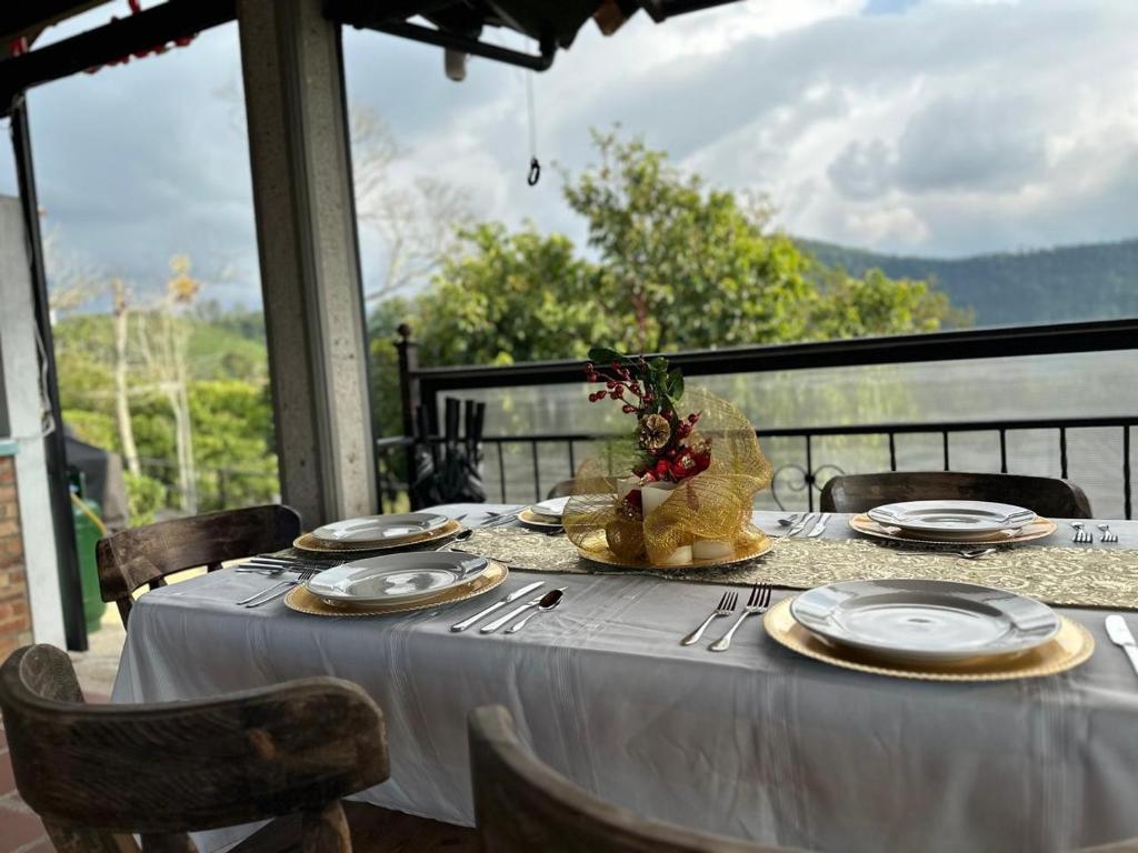 a table with a white table cloth and plates on it at Acaima Café Lodge in Sasaima