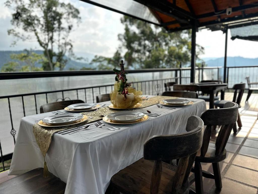 a table with a white table cloth on a balcony at Acaima Café Lodge in Sasaima