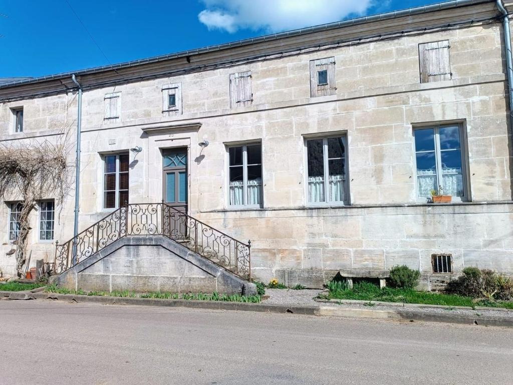 ein Steingebäude mit einer Seitentreppe in der Unterkunft Charmante maison de village à Ménil-sur-Saulx - FR-1-585-172 in Ménil-sur-Saulx