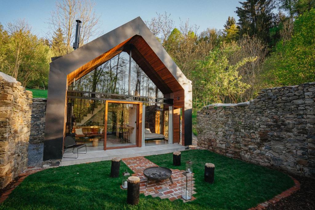 a glass house with a stone wall at Živili in Smilkov