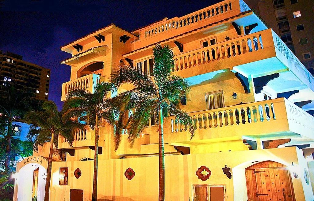 a large building with palm trees in front of it at Acacia Boutique Hotel in San Juan