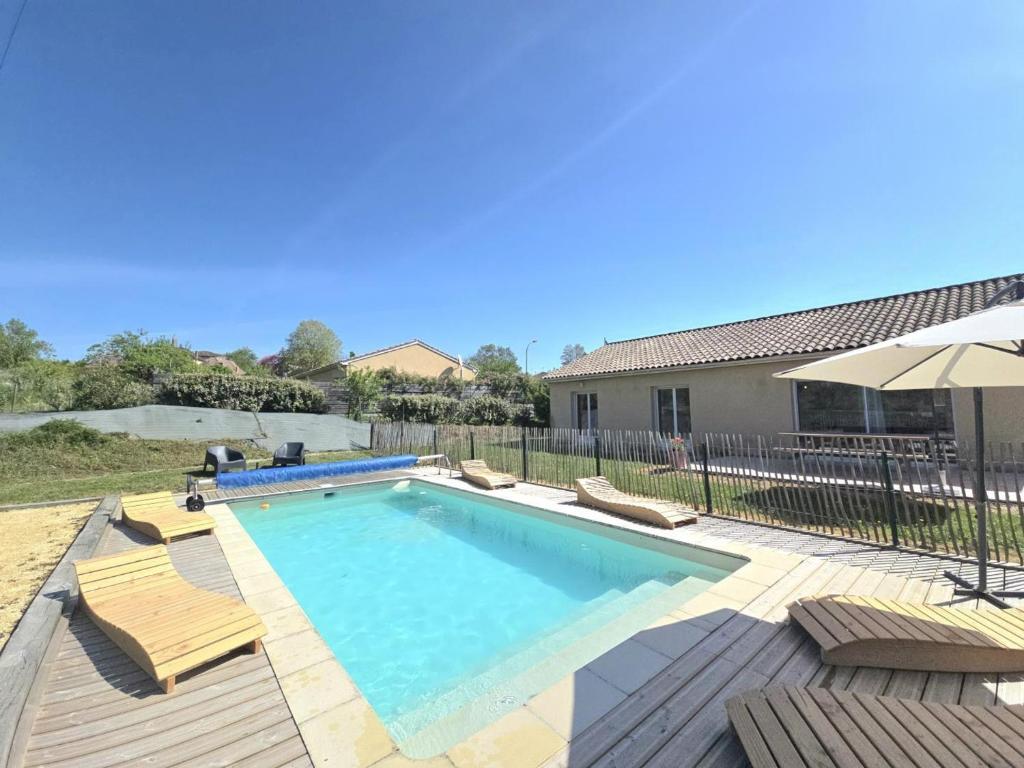 a swimming pool with chairs and an umbrella at Maison périgourdine avec piscine privative, internet et animaux acceptés - FR-1-616-476 in Sainte-Sabine