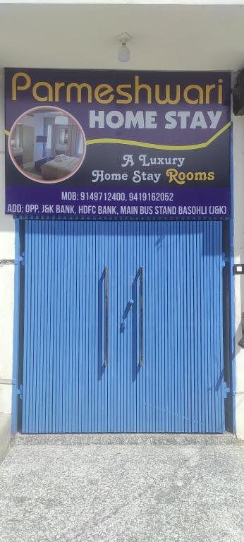 a blue garage door with a sign for a home stay at Parmeshwari HOMESTAY in Jāmb