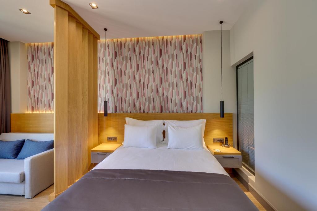 a bedroom with a large bed and a couch at Celeste Bella Luxury Hotel & Spa in Ortakent