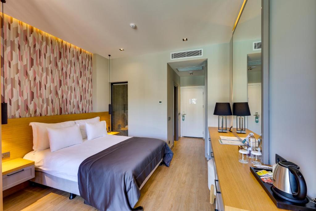 a hotel room with a large bed and a desk at Celeste Bella Luxury Hotel & Spa in Ortakent