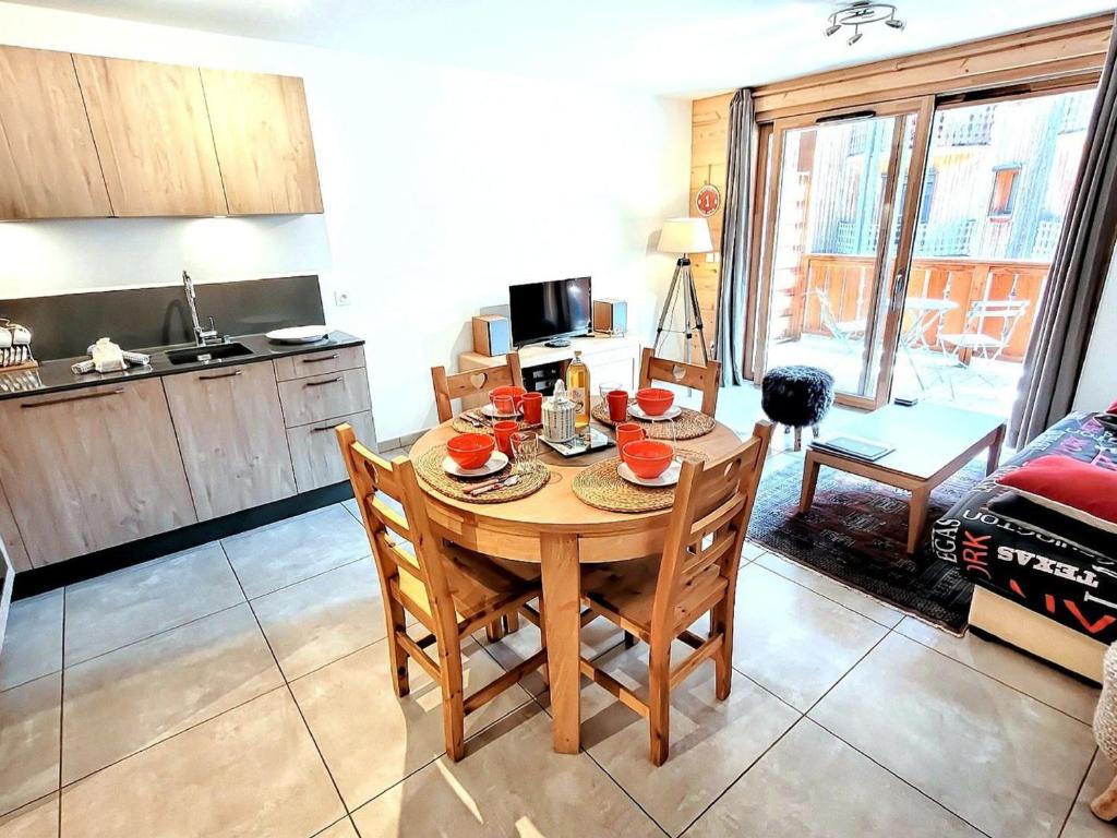 une cuisine et une salle à manger avec une table et des chaises dans l'établissement Appartement 3* au centre des Gets, avec balcon-terrasse, Wifi, et garage - FR-1-598-137, aux Gets