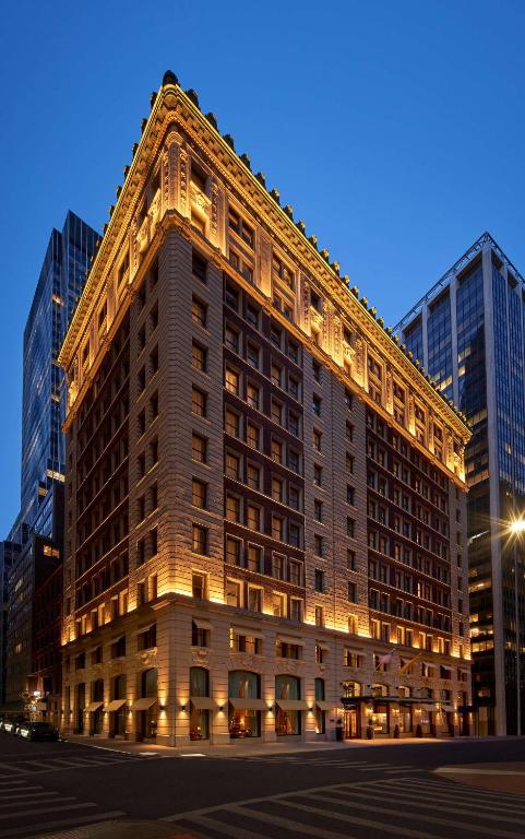 a large building with lights on the side of it at The Wall Street Hotel by Suiteness in New York