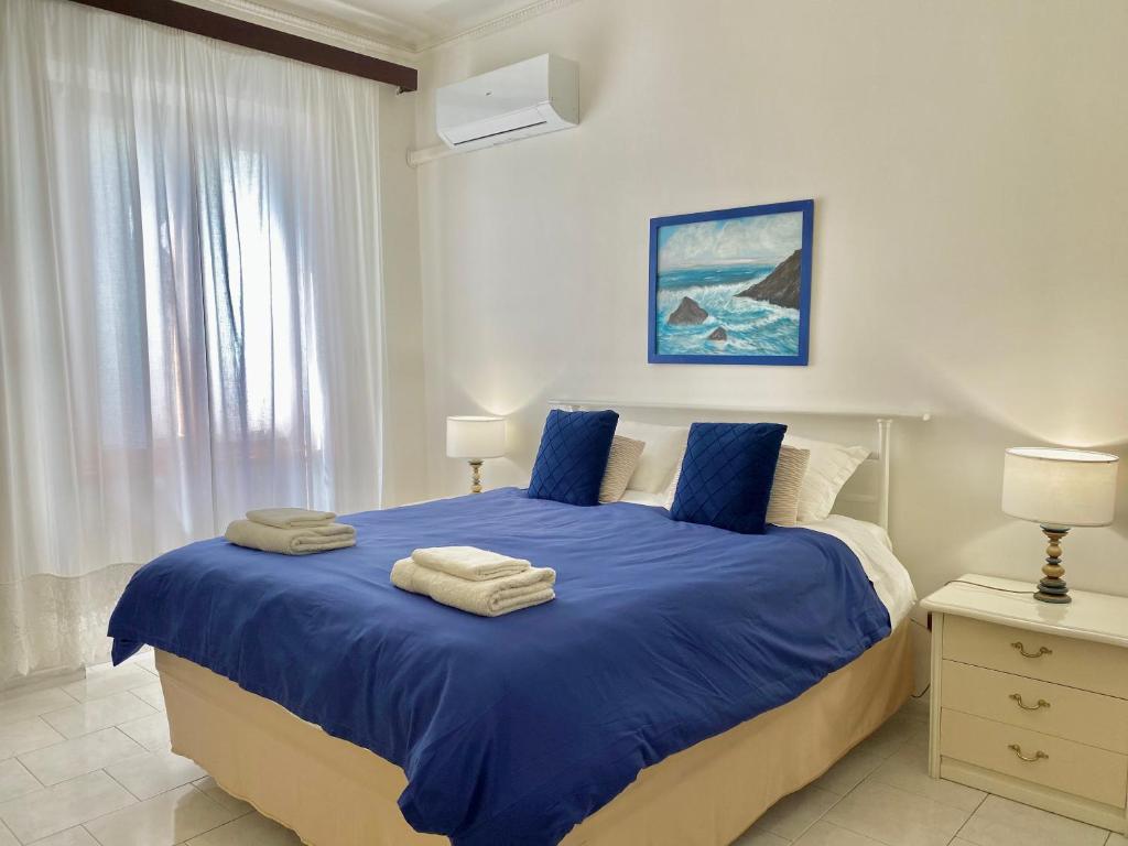 a bedroom with a blue bed with towels on it at Ca del Mare - FREE Parking in La Spezia