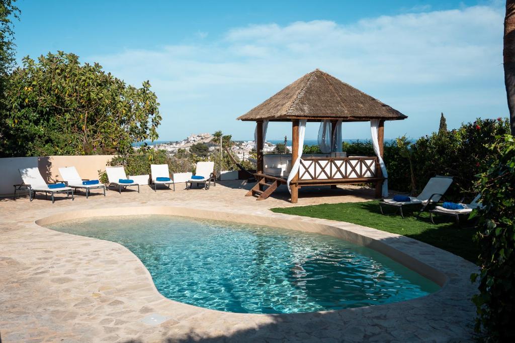 einen Pool mit Pavillon und Stühlen in der Unterkunft Can Calyssa Luxury Villa Near City Center in Ibiza-Stadt