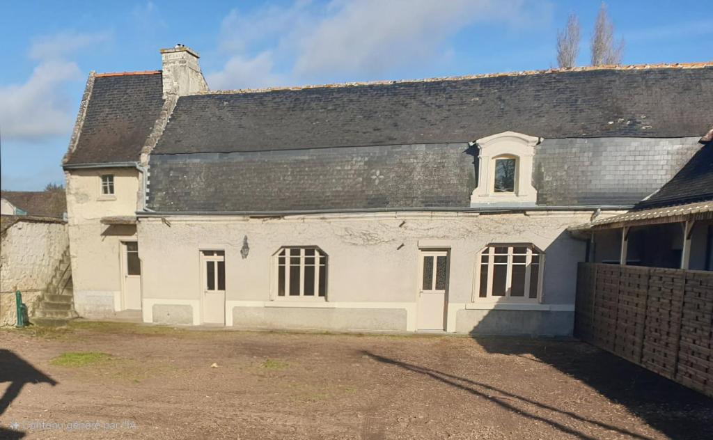 une ancienne maison blanche avec un toit noir dans l'établissement Maison de campagne le Joncher, à Chouzé-sur-Loire