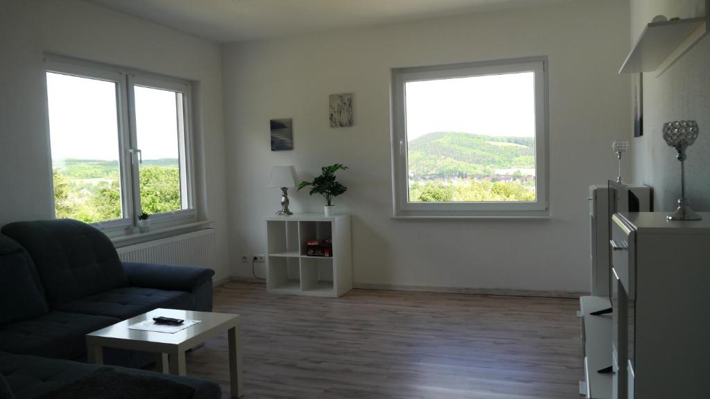 a living room with a couch and two windows at Ferienwohnung Okerblick in Goslar