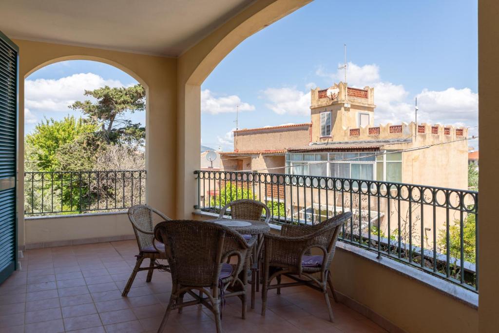 a patio with a table and chairs on a balcony at Villa Laconi in Alghero