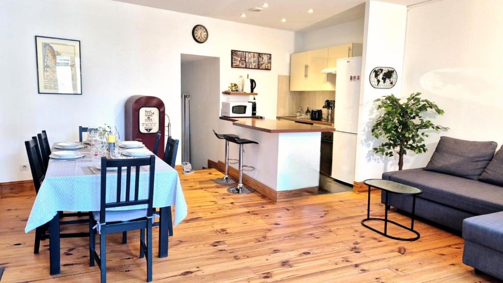 sala de estar y cocina con mesa y sofá en Chez Anton, en Bergerac
