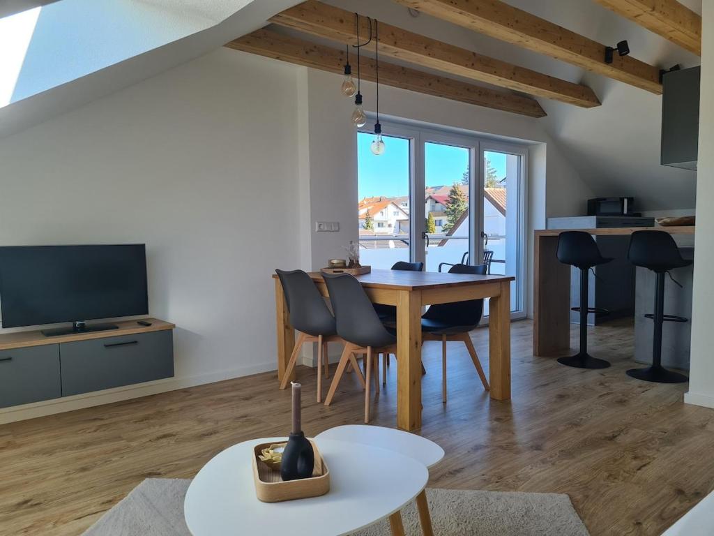 a living room with a table and chairs and a television at Connys FeWo Tal in Großengstingen