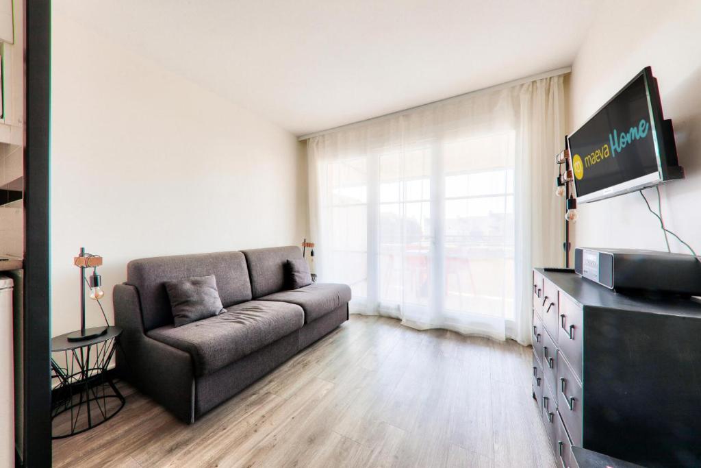 un salon avec un canapé et une grande fenêtre dans l'établissement Résidence Port du Crouesty - maeva Home - Studio bord de mer 4 personnes - Confort MAE-8813, à Arzon