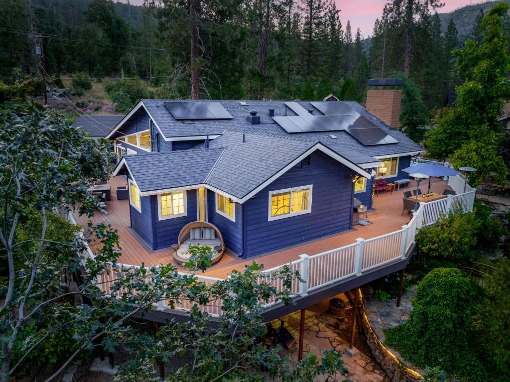 una vista aérea de una casa azul con terraza en Yosemite Creekside Retreat with spa/games/EV Charger and more, en Yosemite Forks
