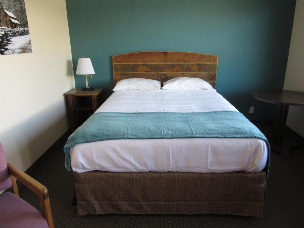 a bedroom with a large bed with a wooden headboard at Al's Westward Ho Motel in West Yellowstone