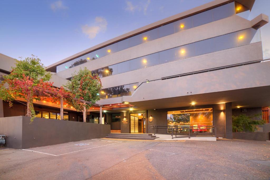 Un edificio con un estacionamiento enfrente. en Townhouse Hotel, en Wagga Wagga