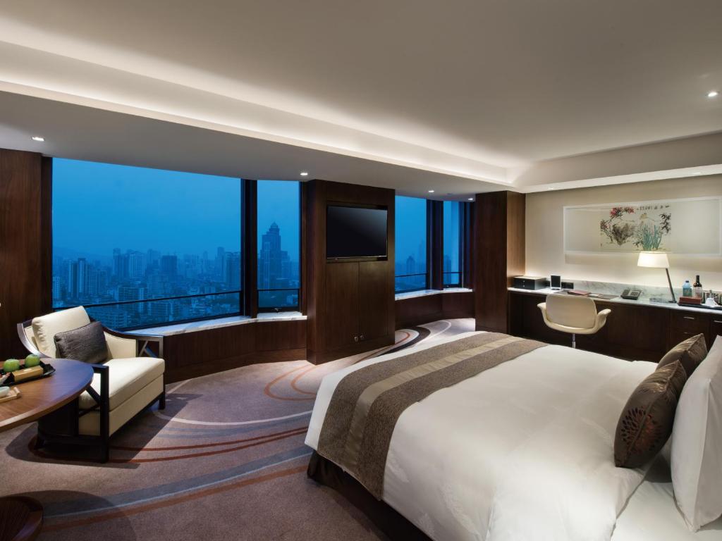 a bedroom with a large bed and a large window at White Swan Hotel in Guangzhou