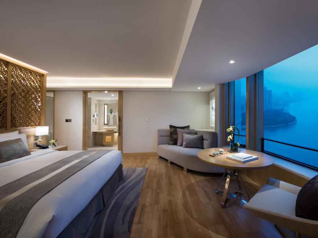 a large bedroom with a large bed and a couch at White Swan Hotel in Guangzhou