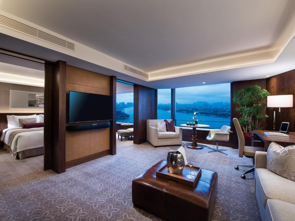 a hotel room with a bed and a television at White Swan Hotel in Guangzhou