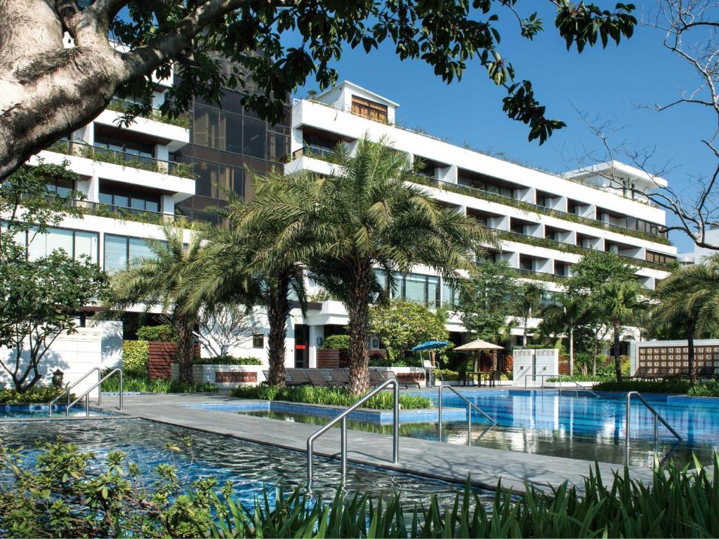 an apartment building with a swimming pool and palm trees at White Swan Hotel in Guangzhou