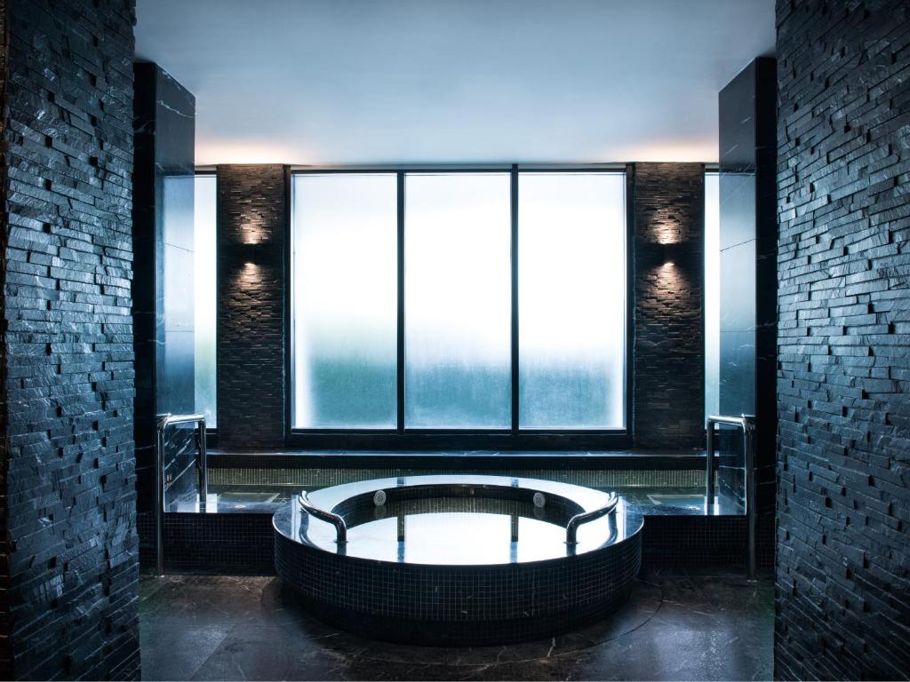 a bath tub in a room with large windows at White Swan Hotel in Guangzhou