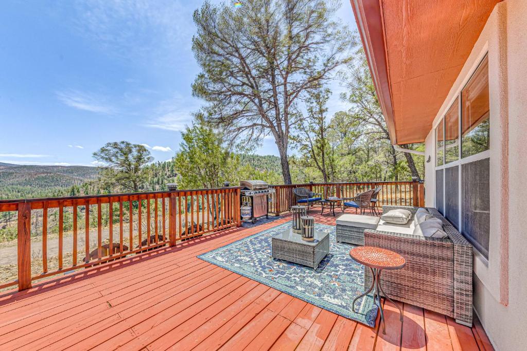 a wooden deck with a couch and chairs on it at Charming Ruidoso House with Deck and Mountain Views! in Ruidoso