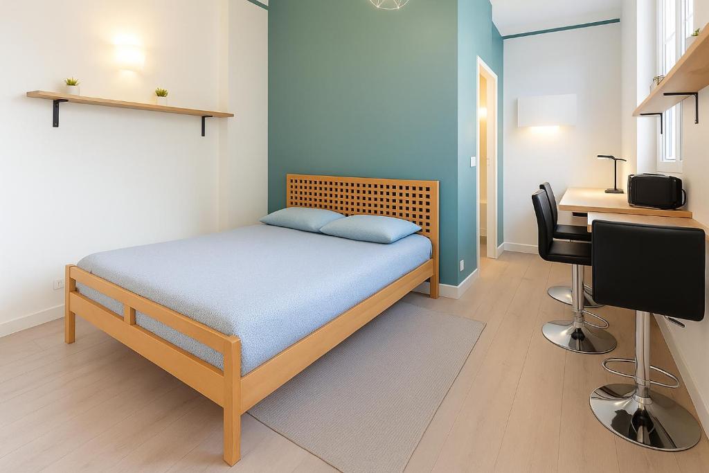 une petite chambre avec un lit et un bureau dans l'établissement Rochefoucauld, à Rouen