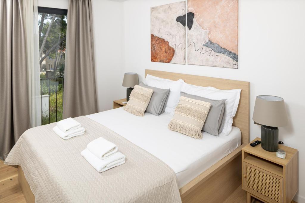 Un dormitorio con una cama con sábanas y almohadas blancas. en Villa Vartal, en Ivan Dolac