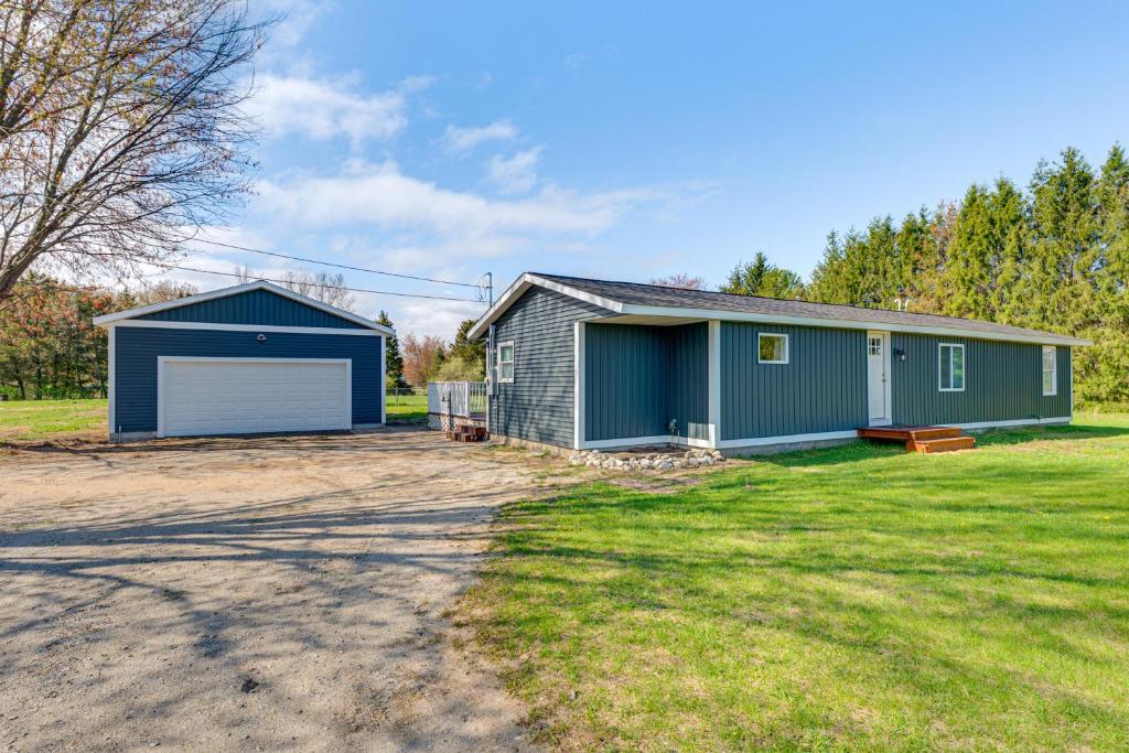 a house with a garage and a yard at Less Than 3 Mi to Double JJ Resort Home with Large Yard! in Rothbury