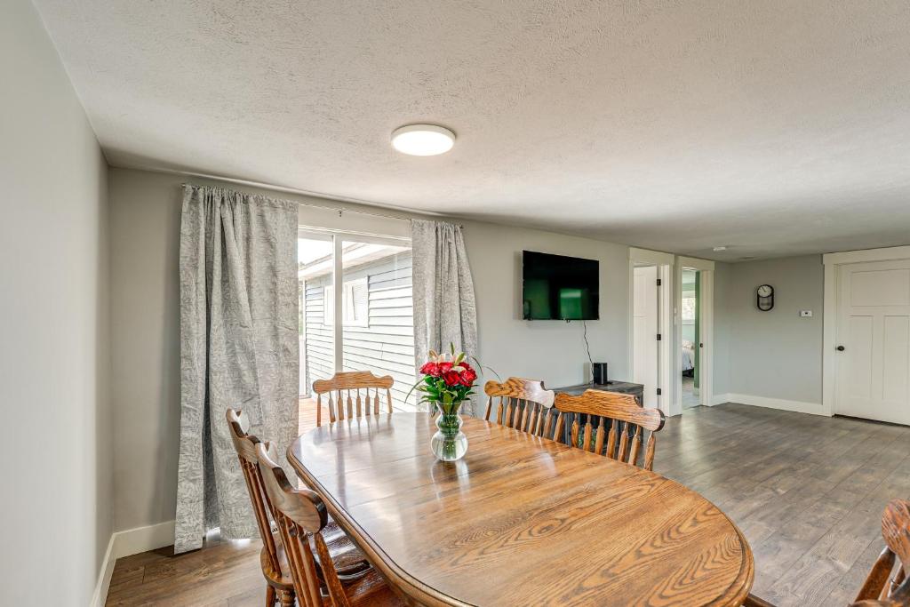 a dining room table with chairs and a vase of flowers at Less Than 3 Mi to Double JJ Resort Home with Large Yard! in Rothbury