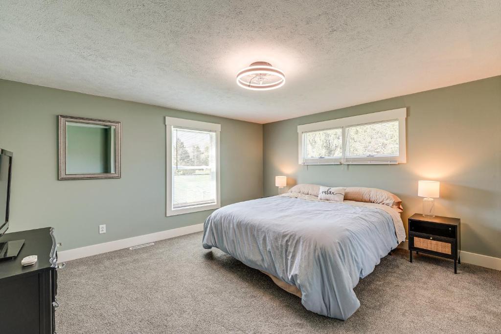 a bedroom with a bed and two windows at Less Than 3 Mi to Double JJ Resort Home with Large Yard! in Rothbury