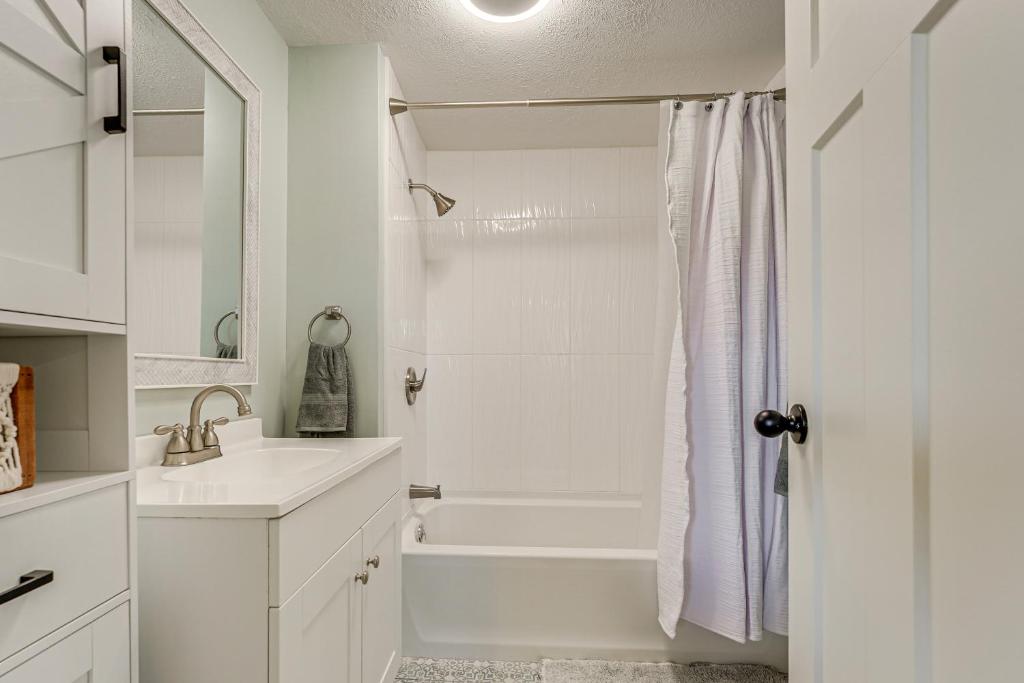 a white bathroom with a shower and a sink at Less Than 3 Mi to Double JJ Resort Home with Large Yard! in Rothbury