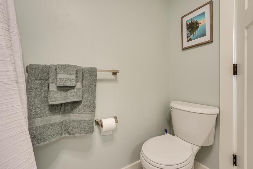 a bathroom with a white toilet and towels at Less Than 3 Mi to Double JJ Resort Home with Large Yard! in Rothbury
