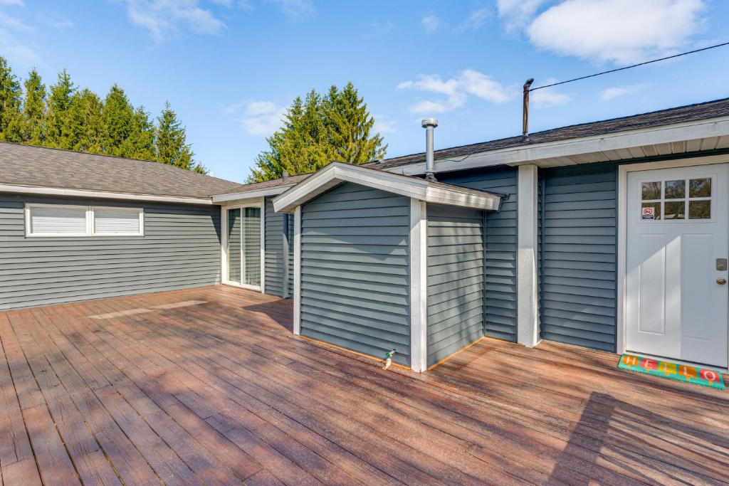 a house with a garage and a wooden deck at Less Than 3 Mi to Double JJ Resort Home with Large Yard! in Rothbury