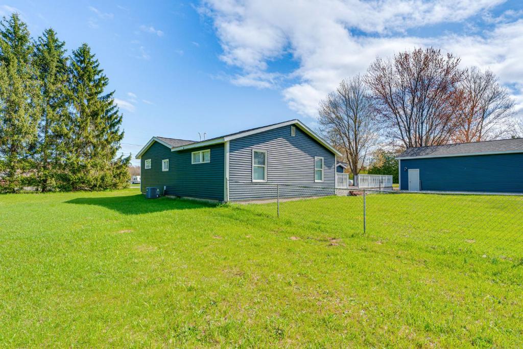 a house in a grassy field next to a house at Less Than 3 Mi to Double JJ Resort Home with Large Yard! in Rothbury